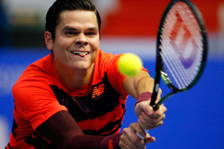 Milos Raonic of Canada returns the ball to Roberto Bautista of Spain during the St. Petersburg Open ATP tennis tournament semifinal match in St.Petersburg, Russia, Saturday, Sept. 26, 2015.