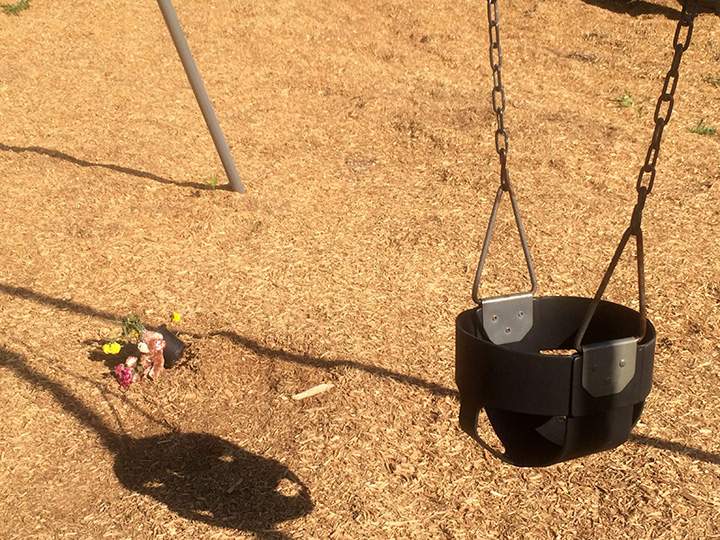 In this photo taken May 26, 2015, a stuffed animal and flowers sit near a swing in Wills Memorial Park in LaPlata, Md.