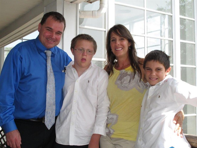 Twelve-year-old Aiden Killoran, second left, poses with his parents Christian Killoran, left, and Terrie Killoran, and his 11-year-old brother, Christian Killoran Jr., Wednesday, Sept. 2, 2015 in Westhampton Beach, N.Y.
