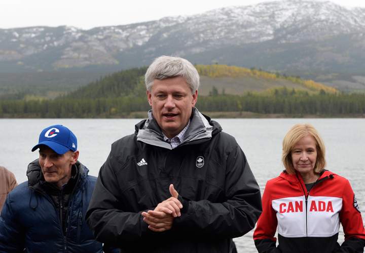 Conservative leader Stephen Harper 
and wife Laureen stand on a float plane dock alongside Conservative candidate Ryan Leef, right, on Schwatka Lake, near Whitehorse, Y.T., on Friday, September 4, 2015. 