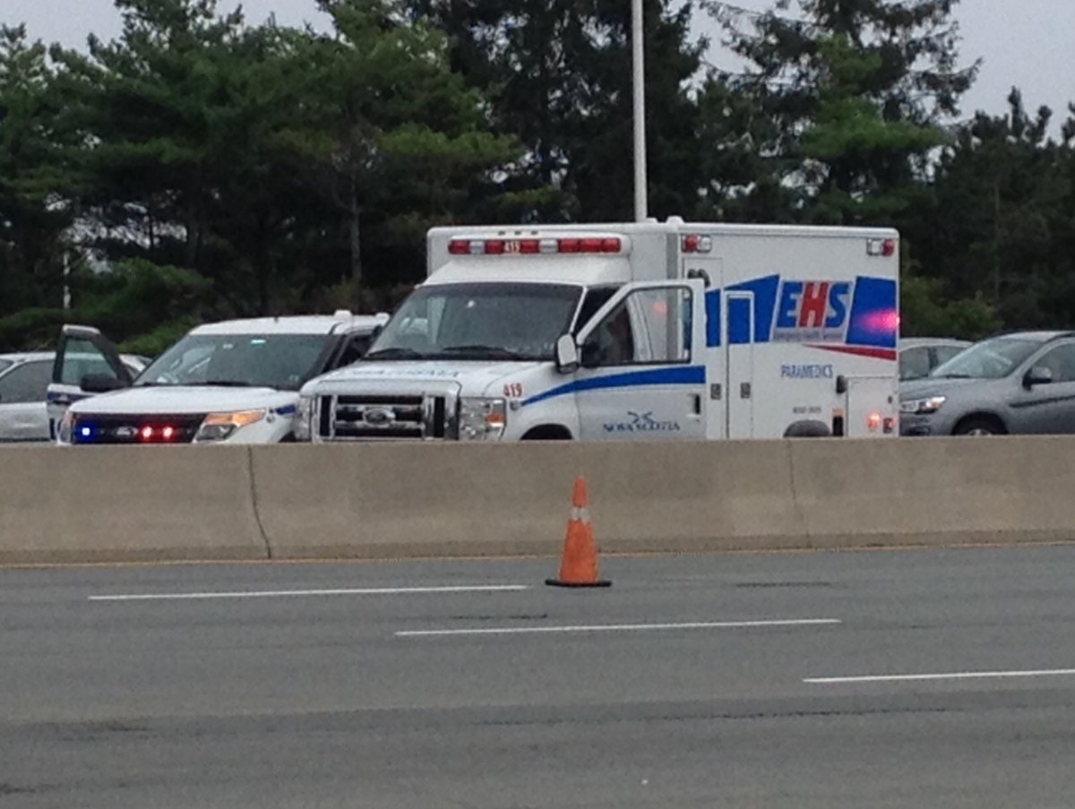 An ambulance with the driver's side window smashed out sits at the MacKay Bridge tolls.