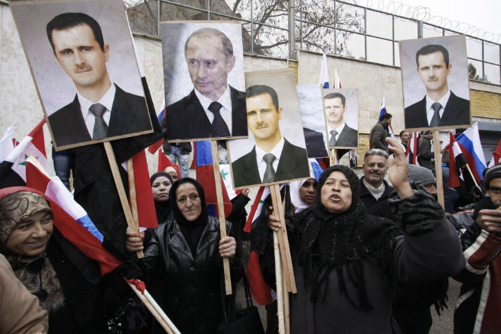 In this Sunday, March 4, 2012 file photo, Syrians hold posters of Syrian President Bashar Assad, far left, and Russian President Vladimir Putin, second left, during a pro-Syrian goverment protest in front of the Russian Embassy in Damascus, Syria. 