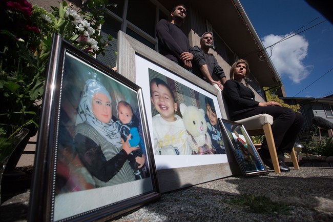 Tima Kurdi, right, aunt of late brothers Alan and Ghalib Kurdi, pauses while speaking to the media outside her home as her son Alan Kerim, left, and husband Rocco Logozzo stand behind her, in Coquitlam, B.C., on Friday September 4, 2015. Alan, his older brother Ghalib and their mother Rehanna died as they tried to reach Europe from Syria.