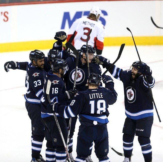 The Winnipeg Jets celebrate after Andrew Ladd scored late in the third period to tie the Ottawa Senators during pre-season NHL hockey action in Winnipeg.
