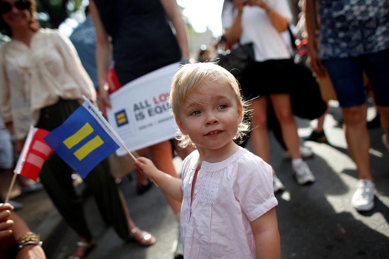 Julia Watson-Gallagher, 2, joins her father Robert Watson (not pictured) and other members of the LGBT community and their supporters as they gather to celebrate two decisions by the U.S. Supreme Court, one to invalidate parts of the Defense of Marriage Act and another to uphold a lower court ruling that struck down California's controversial Proposition 8, during a rally in New York's Greenwich Village, Wednesday, June 26, 2013. Julia is the daughter of same-sex parents. 