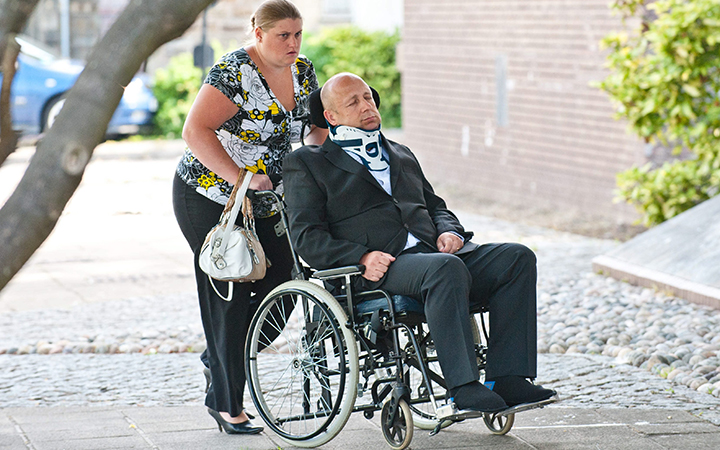 Alan Night pushed in a wheelchair to Swansea Crown Court by his wife Helen
Alan Knight pretended he was quadriplegic to avoid fraud trial at Swansea Crown Court, Wales, Britain on Oct. 21, 2014.