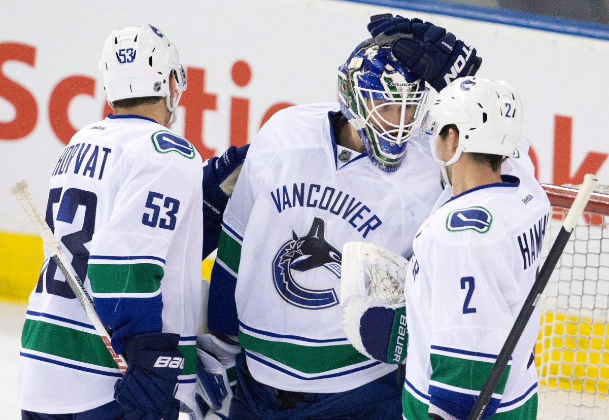 Vancouver Canucks' Bo Horvat (53), goalie Jacob Markstrom (25) and Dan Hamhuis (2) celebrate the win over the Edmonton Oilers during NHL pre-season action. 
