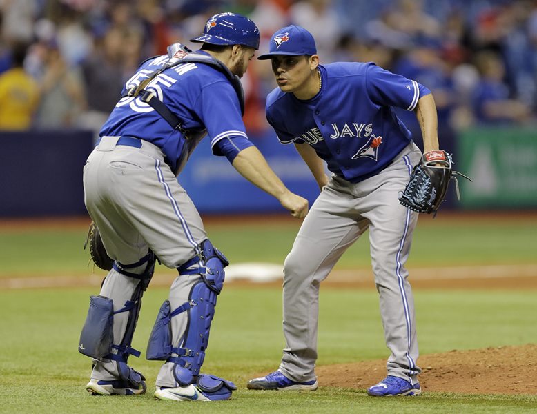 Toronto Blue Jays relief pitcher Roberto Osuna, right, celebrates with catcher Russell Martin after the Blue Jays defeated the Tampa Bay Rays 8-4 during a baseball game Friday, Oct. 2, 2015, in St. Petersburg, Fla. 