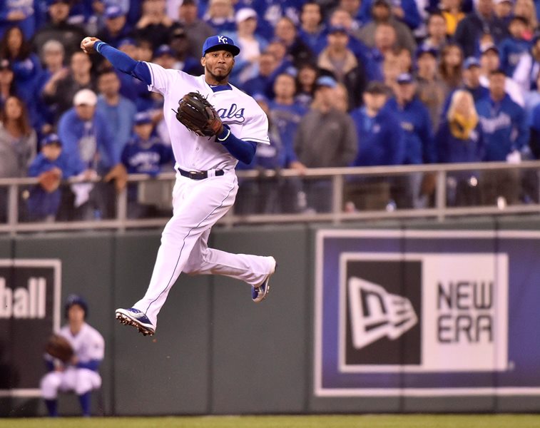Kansas City Royals' shortstop Alcides Escobar leaps and fires to second base to force out Toronto Blue Jays' Dioner Navarro during ninth inning game 1 American League Championship Series baseball action in Kansas City, Mo. on Friday, Oct. 16, 2015.