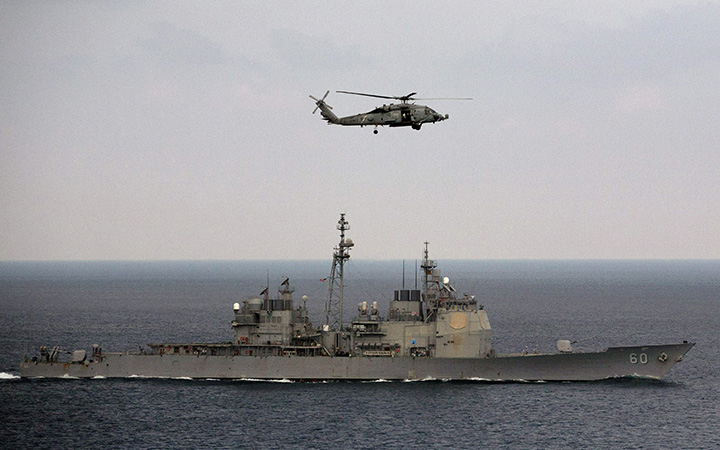A U.S. Navy helicopter approaches to land on the deck of aircraft carrier USS Theodore Roosevelt (CVN 71), a missile cruiser and a nuclear-powered submarine, as the USS Normady sails in the Bay of Bengal during Exercise Malabar 2015, some 152 miles off eastern coast of Chennai, India, Saturday, Oct. 17, 2015. 