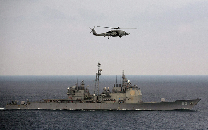 A U.S. Navy helicopter approaches to land on the deck of aircraft carrier USS Theodore Roosevelt (CVN 71), a missile cruiser and a nuclear-powered submarine, as the USS Normady sails in the Bay of Bengal during Exercise Malabar 2015, some 152 miles off eastern coast of Chennai, India, Saturday, Oct. 17, 2015. 