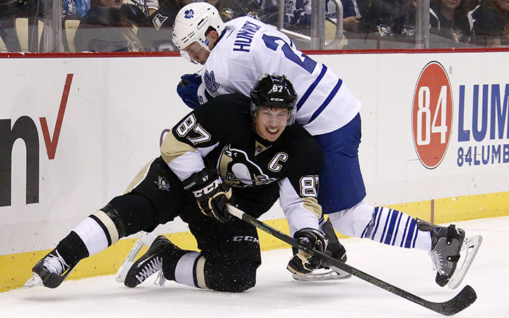 Pittsburgh Penguins' Sidney Crosby gets off a pass with Toronto Maple Leafs' Matt Hunwick on top of him during the second period of an NHL hockey game in Pittsburgh, Saturday, Oct. 17, 2015.
