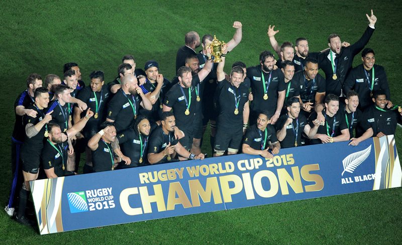 New Zealand All Blacks captain Richie McCaw holds the Webb Ellis trophy aloft as his teammates celebrate after their Rugby World Cup final win over Australia at Twickenham Stadium, London, Saturday, Oct. 31, 2015.