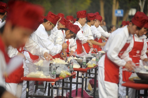 300 people cook fried rice to attempt a Guinness World Records for the "Largest Fired Rice" on October 22, 2015 in Yangzhou, Jiangsu Province of China. 300 people cooked 4.19-ton fried rice in Yangzhou and failed to break the Guinness World Records for the reason of a waste of food.  (Photo by ChinaFotoPress/ChinaFotoPress via Getty Images).