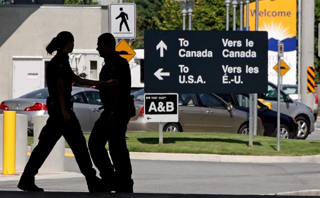 Canadian border guards are silhouetted as they replace each other at an inspection booth at the Douglas border crossing on the Canada-USA border in Surrey, B.C. 