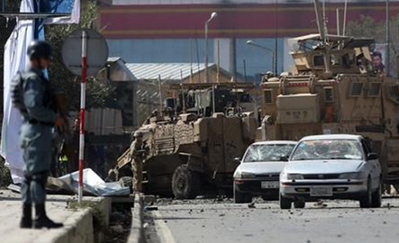 Afghan and foreign soldiers inspect the site of a bomb attack that targeted several armored vehicles belonging to forces attached to the NATO Resolute Support Mission, in downtown of Kabul, Afghanistan, Sunday, Oct. 11, 2015. Gen. Abdul Rahman Rahimi, the Kabul city police chief, said that three Afghan civilians were wounded in the attack that damaged one of the vehicles but caused no fatalities. 