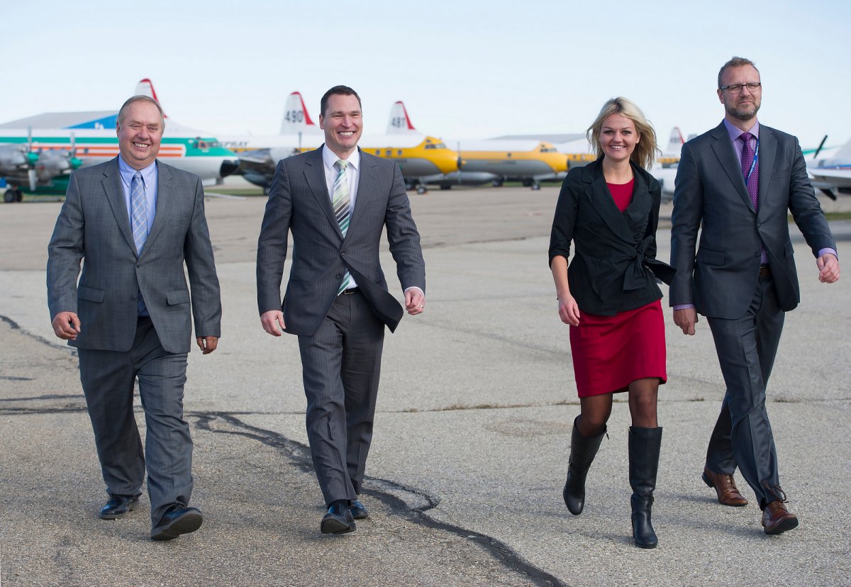 Municipal Affairs Minister Deron Bilous, Red Deer County Mayor Jim Wood (far left), City of Red Deer Mayor Tara Veer and R.J. Steenstra (CEO of Red Deer Regional Airport Authority) check out the aircraft on display after Tuesday's announcement. 