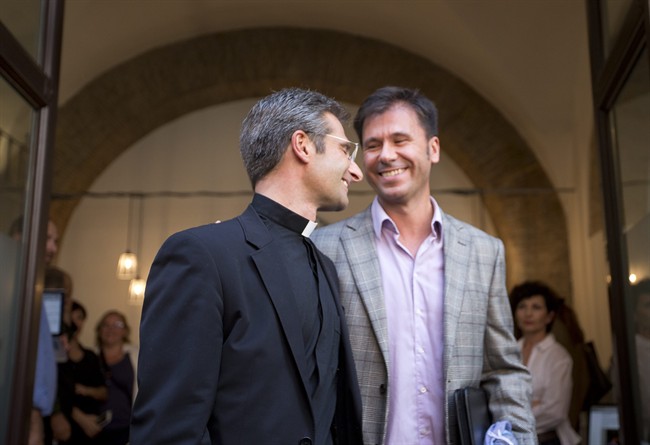 Monsignor Krzysztof Charamsa, left, and his partner Eduard, surname not given, leave a restaurant after a press conference in downtown Rome, Saturday Oct. 3, 2015. Vatican on Saturday fired a monsignor who came out as gay on the eve of a big meeting of the world's bishops to discuss church outreach to gays, divorcees and more traditional Catholic families.