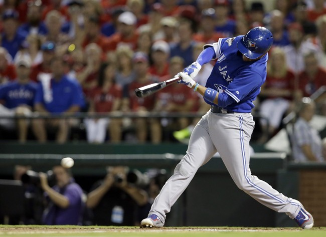 Toronto Blue Jays second baseman Ryan Goins (17) hits an RBI against the Texas Rangers during the third inning in Game 3 of baseball's American League Division Series Sunday, Oct. 11, 2015, in Arlington, Texas.