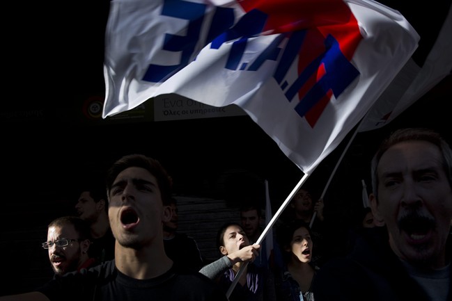 Protesters from communist-affiliated party PAME wave a flag as they chant anti-austerity slogans outside the Labor Ministry in Athens, Thursday, Oct. 15, 2015.