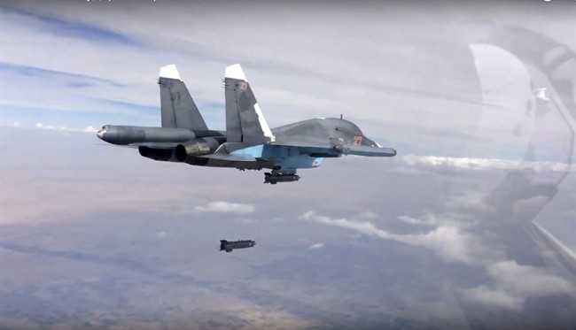 In this file photo made from the footage taken from Russian Defense Ministry official website on Friday, Oct. 9, 2015, a bomb is released from Russian Su-34 strike fighter in Syria.