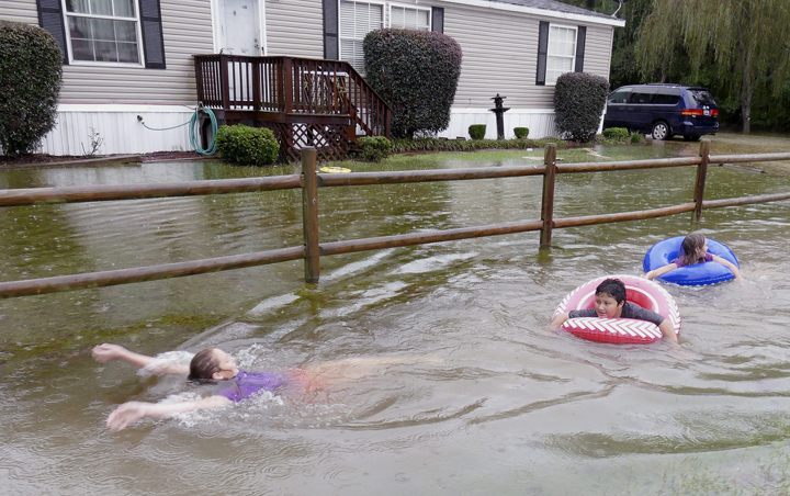 Children play in the flood waters outside of Conway, S.C., Sunday, Oct. 4, 2015.