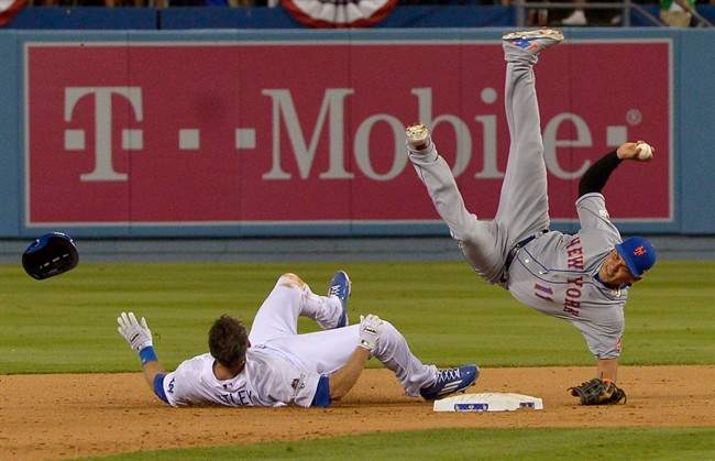 New York Mets shortstop Ruben Tejada falls after a slide by Los Angeles Dodgers' Chase Utley during the seventh inning of an NL Division Series baseball game Saturday, Oct. 10, 2015, in Los Angeles.
