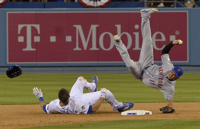 New York Mets shortstop Ruben Tejada falls after a slide by Los Angeles Dodgers' Chase Utley during the seventh inning of an NL Division Series baseball game Saturday, Oct. 10, 2015, in Los Angeles.