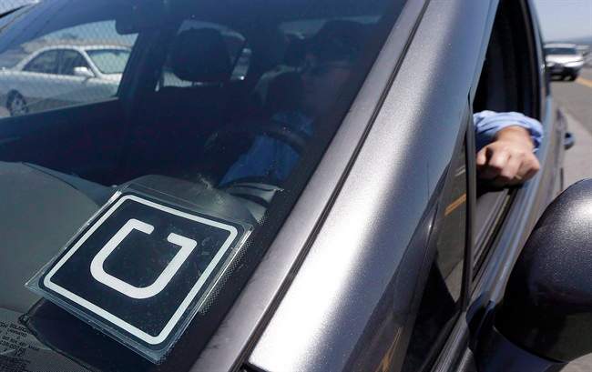 An Uber driver sits in his car parked near the San Francisco International Airport parking area in San Francisco, Wednesday, July 15, 2015.