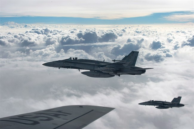 Royal Canadian Air Force CF-18 Hornets depart after refueling with a KC-135 Stratotanker assigned to the 340th Expeditionary Air Refueling Squadron, October 30, 2014, over Iraq.