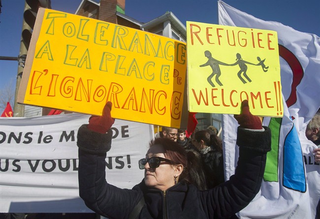 A woman holds up signs during a demonstration to denounce the anti-Islam group PEGIDA in Montreal on March 28, 2015.