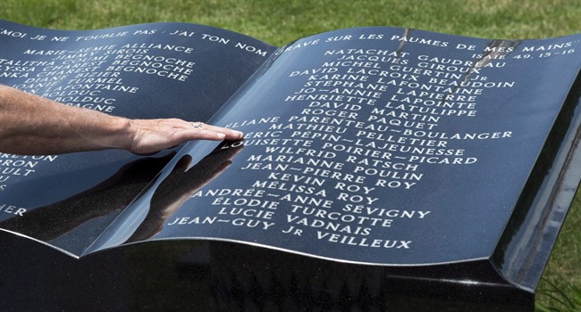In this 2014 file photo, a man touches a stone monument in front of Ste-Agnes church following a memorial service for the 47 victims of an oil-filled train derailment in Lac-Megantic, Que. Residents of the small town are marking the fourth anniversary of the tragedy that killed 47 people and destroyed much of the downtown core. Thursday, July 6, 2017.