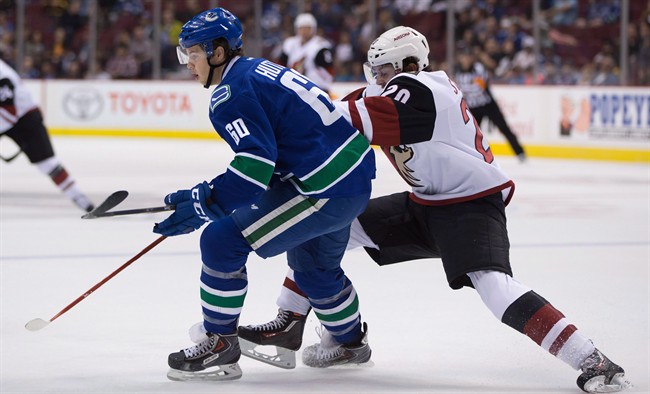 FILE -- Arizona Coyotes' Dylan Strome, right, checks Vancouver Canucks' Ben Hutton during the first period of a preseason NHL hockey game in Vancouver, B.C., on Monday, September 28, 2015.