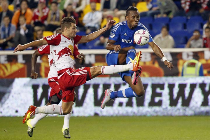 Montreal Impact forward Didier Drogba, right, and New York Red Bulls defender Damien Perrinelle compete for the ball during the first half of an MLS soccer match Wednesday, Oct. 7, 2015, in Harrison, N.J. 