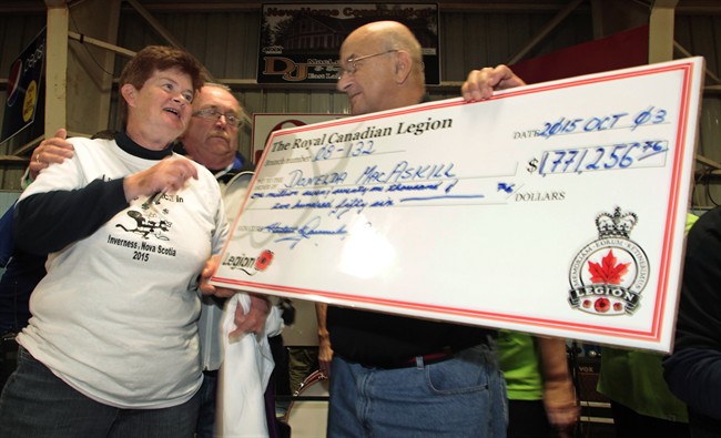 Donelda MacAskill, 62, of Englistown, N.S., receives a cheque for more than $1.7 million after flipping over the ace of spades in the final Chase the Ace draw in Inverness, Nova Scotia on Saturday Oct. 4, 2015.