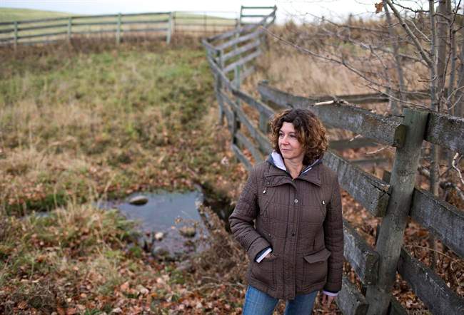 Lonni Saken is pictured by a contaminated source of water on her farm near Edson, Alta., on Friday, Oct. 30, 2015. An Alberta energy company has been ordered to transport water to a family dairy farm where the ground water has been contaminated by chemicals from a nearby gas plant. 