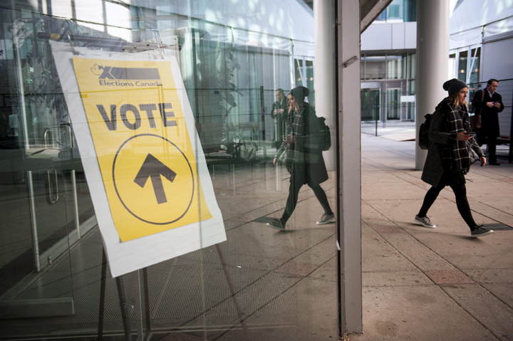 An Elections Canada sign points voters towards the polls at Metro Hall in Toronto on Monday, Oct. 19, 2015.