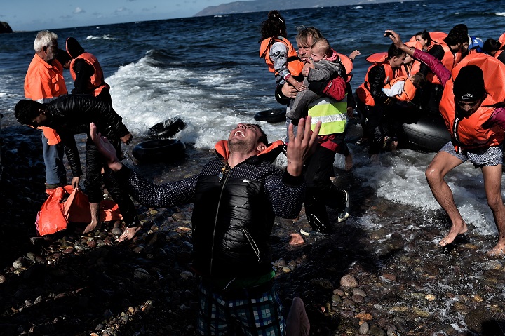 A man reacts as he arrives, with other refugees and migrants, on the Greek island of Lesbos, on October 28, 2015, after crossing the Aegean sea from Turkey. At least five migrants including three children, died on October 28, 2015 after four boats sank between Turkey and Greece, as rescue workers searched the sea for dozens more, the Greek coastguard said. The new accidents brought to 34 the number of migrants found dead in Greek waters this month, according to an AFP tally based on data from Greek port police. Since the start of the year, 560,000 migrants and refugees have arrived in Greece by sea, out of over 700,000 who have reached Europe via the Mediterranean, according to the International Office for Migration (IOM).