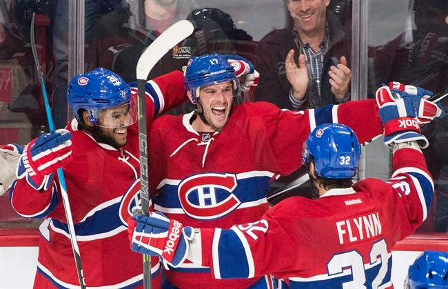 Montreal Canadiens' Torrey Mitchell celebrates with teammates Devante Smith-Pelly, left, and Brian Flynn after scoring against the Saint Louis Blues during third period NHL hockey action in Montreal, Tuesday, October 20, 2015.