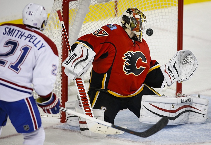 Montreal Canadiens' Devante Smith-Pelly, left, scores on Calgary Flames' goalie Joni Ortio, of Finland, during second period NHL hockey action in Calgary, Friday, Oct. 30, 2015. 