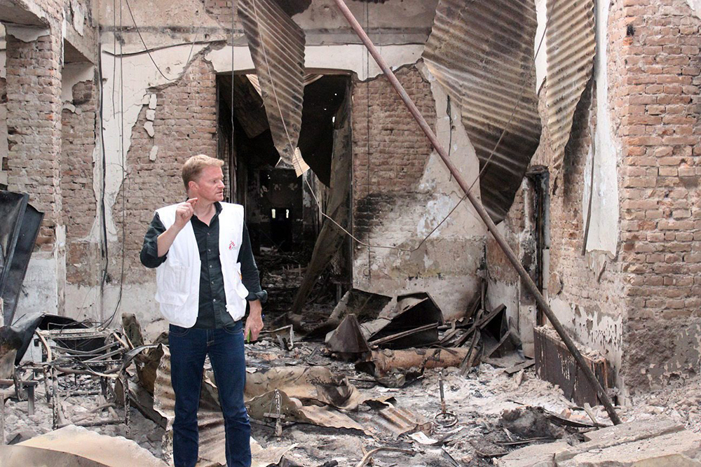 In this Friday, Oct. 16, 2015 photo, Christopher Stokes, the general director of the medical charity, Doctors Without Borders, stands amid the charred remains of the organization's hospital, after it was hit by a U.S. airstrike in Kunduz, Afghanistan. 