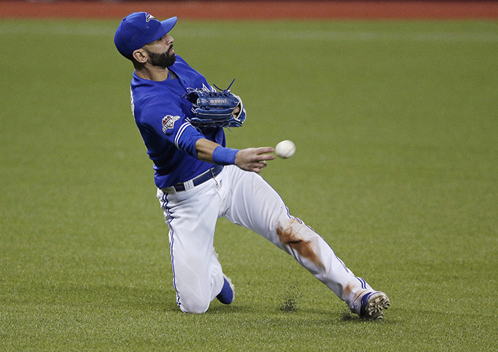Toronto Blue Jays right fielder Jose Bautista fields a ball hit by Kansas City Royals' Alcides Escobar during the ninth inning in Game 4 of baseball's American League Championship Series on Tuesday, Oct. 20, 2015, in Toronto. (AP Photo/Charlie Riedel).