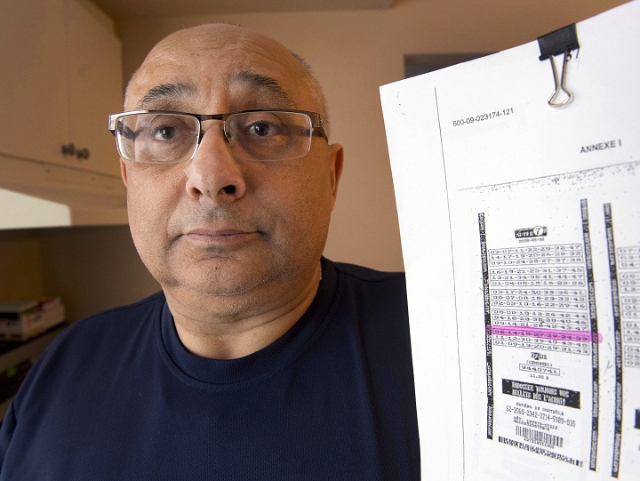 Joel Ifergan holds up a copy of his lottery ticket at his home, Thursday, January 29, 2015 in Montreal. The Supreme Court of Canada refused to hear his case claiming he is owed $13-million for having the winning numbers but the ticket was printed seven seconds after the deadline. Now Ifergan is seeking to launch a class-action suit against Loto-Quebec. Saturday Oct. 31, 2015.