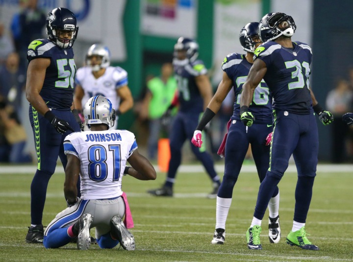 Seattle Seahawks strong safety Kam Chancellor, right, celebrates his tackle of Detroit Lions wide receiver Calvin Johnson in the second half of an NFL football game, Monday, Oct. 5, 2015, in Seattle. The Seahawks beat the Lions 13-10. 