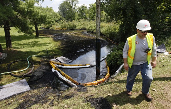 FILE - In this July 29, 2010 file photo, a worker monitors the water in Talmadge Creek in Marshall Township, Mich., near the Kalamazoo River as oil from a ruptured pipeline, owned by Enbridge Inc, is vacuumed out the water. The U.S. Department of Transportation wants to expand rules for pipelines carrying oil, gasoline and other hazardous liquids inspections requirements to include rural areas that are currently exempt, and for companies to more closely analyze the results of their inspections.
