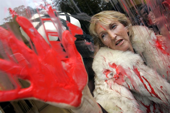 In this Oct. 2, 2006 file photo, People for the Ethical Treatment of Animals (PETA) President Ingrid Newkirk protests the use of animal fur in fashion in a Jean-Paul Gaultier shop in Paris after spraying red paint on the shop window. 