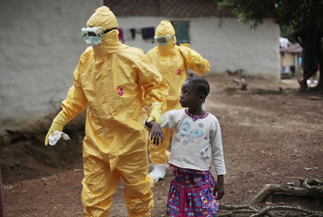 In this Tuesday, Sept. 30, 2014 file photo, Nine-year-old Nowa Paye is taken to an ambulance after showing signs of the Ebola infection in the village of Freeman Reserve, about 30 miles north of Monrovia, Liberia.