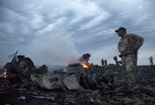 In this July 17, 2014 file photo, people walk amongst the debris at the crash site of a passenger plane near the village of Grabovo, Ukraine. Malaysia Airlines Flight 17 broke up high over eastern Ukraine in 2014, killing all 298 people on board. (AP Photo/Dmitry Lovetsky, File)