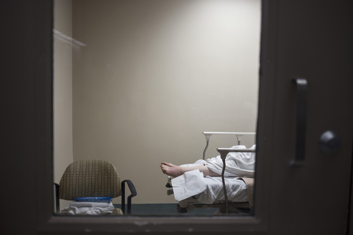 A patient's feet are seen through a hospital room door in the emergency department of the Toronto East General Hospital.