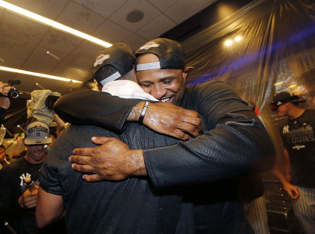 New York Yankees starting pitcher CC Sabathia embraces a teammate after he helped the Yankees clinch a wild card berth in the playoffs after the Yankees defeated the Boston Red Sox 4-1 in a baseball game in New York, Thursday, Oct. 1, 2015.